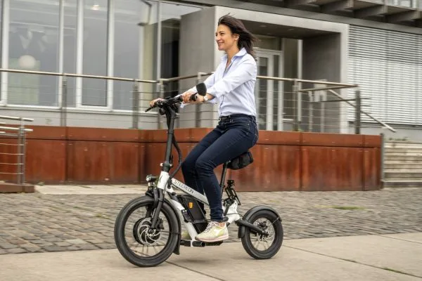 Frau fährt einen STEEREON E-Scooter mit Sitz