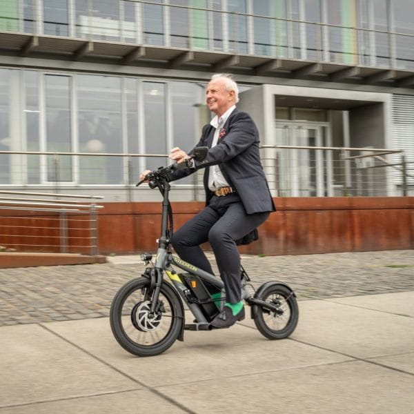 Mann fährt den STEEREON C30 E-Scooter mit Sitz durch die Stadt