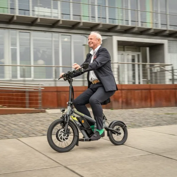 Mann fährt den STEEREON C30 E-Scooter mit Sitz durch die Stadt