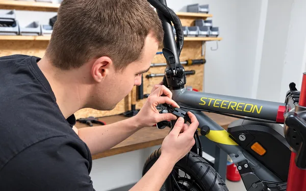 Mitarbeiter bei der Reparatur eines STEEREON E-Scooters in der Werkstatt